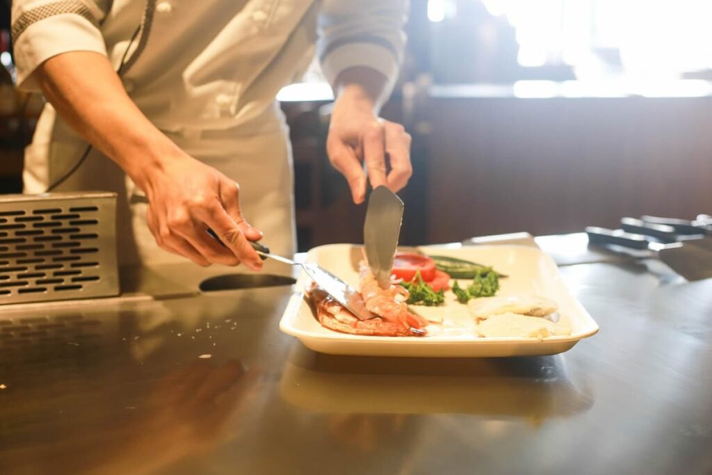 Imagem mostra chefe de cozinha preparando um delicioso prato em um dos melhores restaurantes em elo Horizonte.