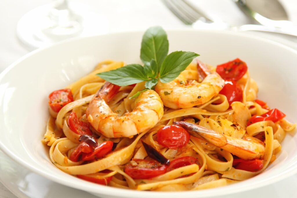 Imagem mostra um saboroso prato de fettuccine com camarão.