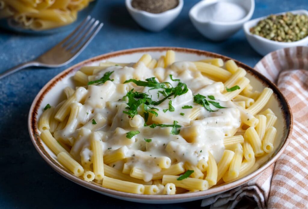 Imagem mostra macarrão italiano com molho de queijos.