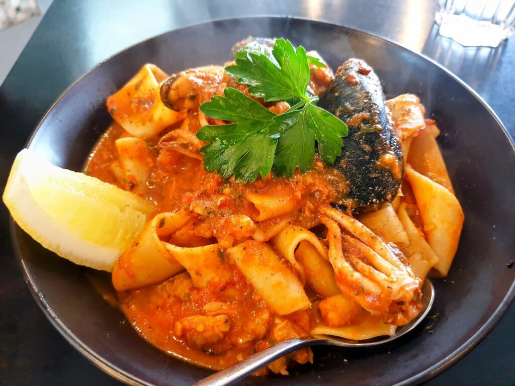 Imagem mostra prato de pappardelle com frutos-do-mar.