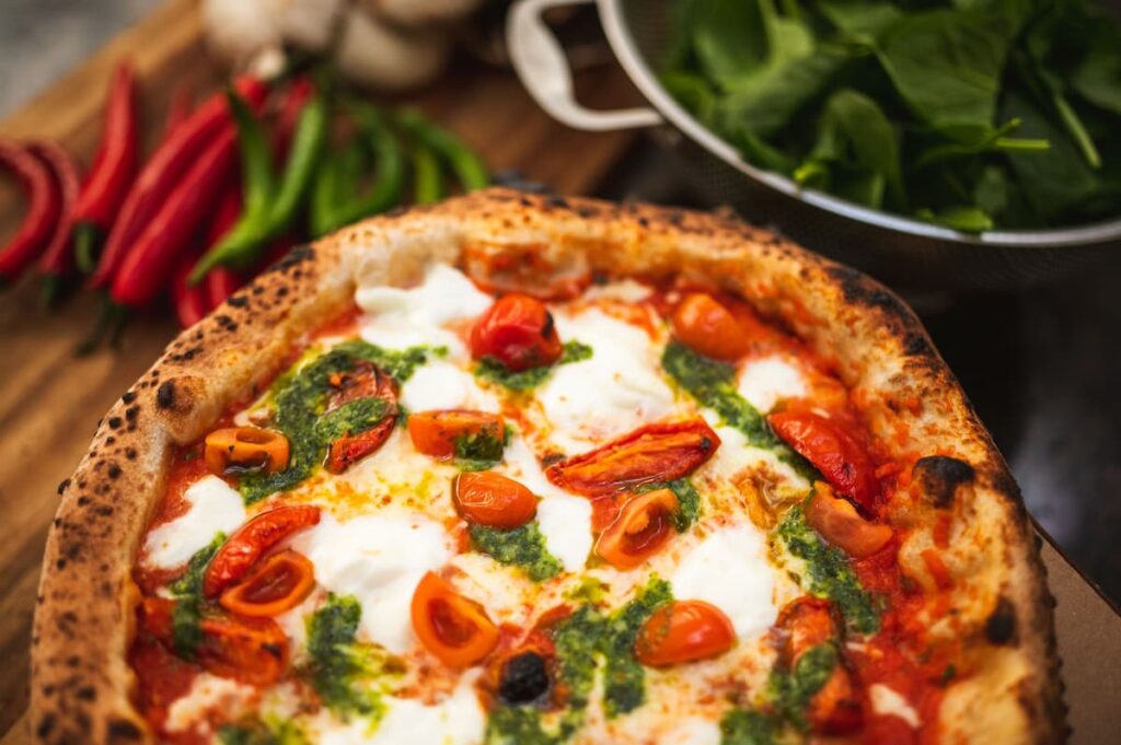 Imagem mostra pizza salgada bem assada e muito suculenta.