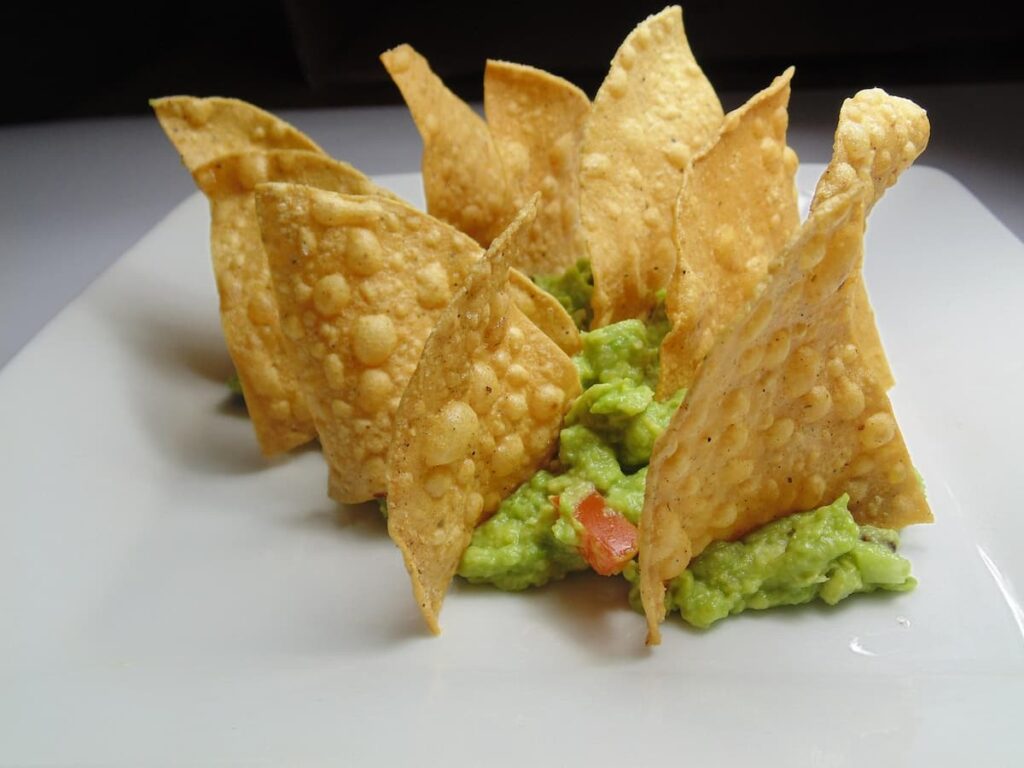 Imagem mostra deliciosos nachos com molho de abacate.